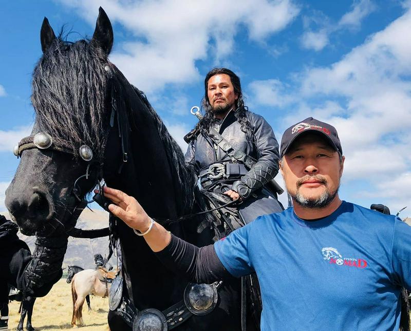 Zhaidarbek Kunguzhinov holds the reigns of horse with a Nomad Stunts rider looking on
