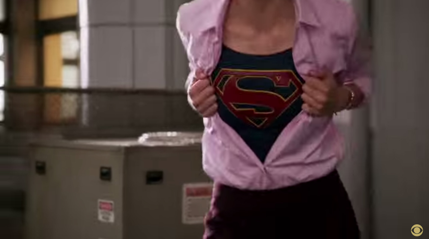 Supergirl reveals her S on her costume just like Superman ripping her shirt open