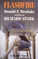 Flashfire novel cover art of lady sitting in a chair with legs crossed, reaching under a table to get a gun that's taped to the underside